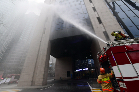 민방위 훈련이 실시된 지난 3월 25일 서울 중구의 한 건물에서 소방관들이 화재진압 훈련을 하고 있다.