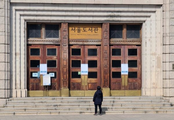 한 시민이 서울시도서관의 무기휴관 공고를 읽고 있다.