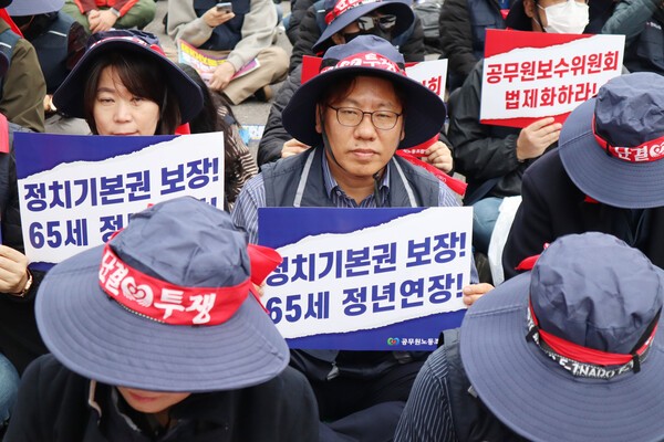 신동근 공무원연맹 위원장(가운데)이 지난 8일 서울 여의대로에서 열린 한국노동자대회에 참석, 정치기본권 보장과 65세 정연 연장을 요구하는 손 펫말을 들어보이고 있다. 공무원연맹 제공